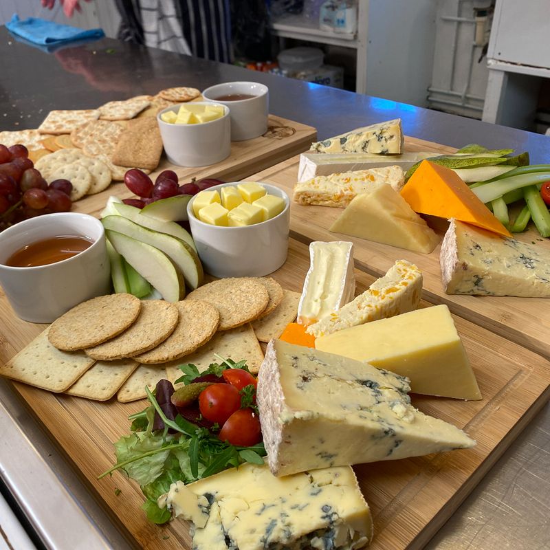 A cheese board with crackers, grapes and chutney